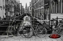 bike locked to canal guard black and white amsterdam holland