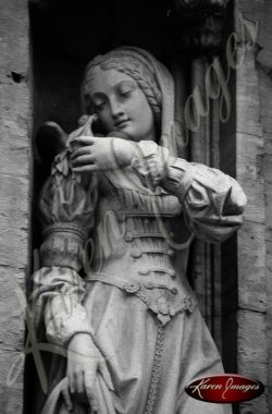 Black and white of brugge belgium statue of maiden with dove on shoulder